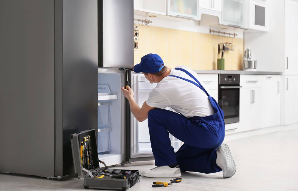 Technician inspecting a refrigerator